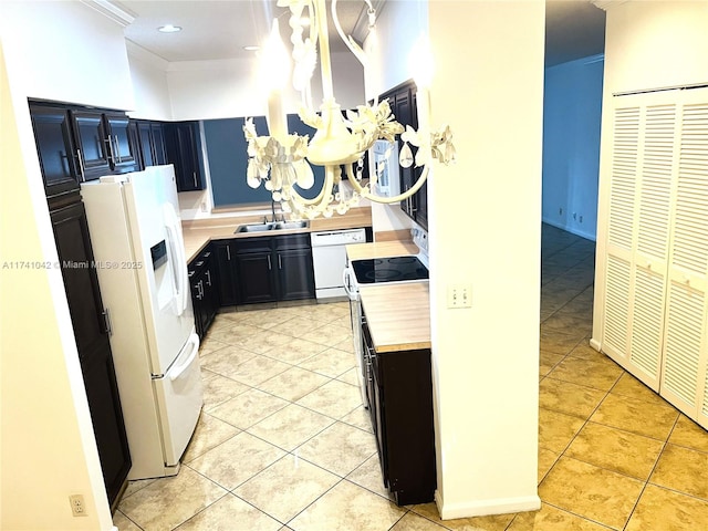 kitchen featuring pendant lighting, sink, light tile patterned floors, crown molding, and white appliances