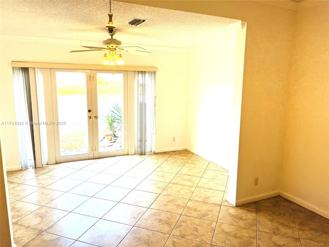 spare room featuring french doors, ceiling fan, a textured ceiling, and light tile patterned floors