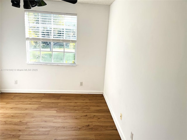 unfurnished room featuring hardwood / wood-style flooring, ceiling fan, and a textured ceiling