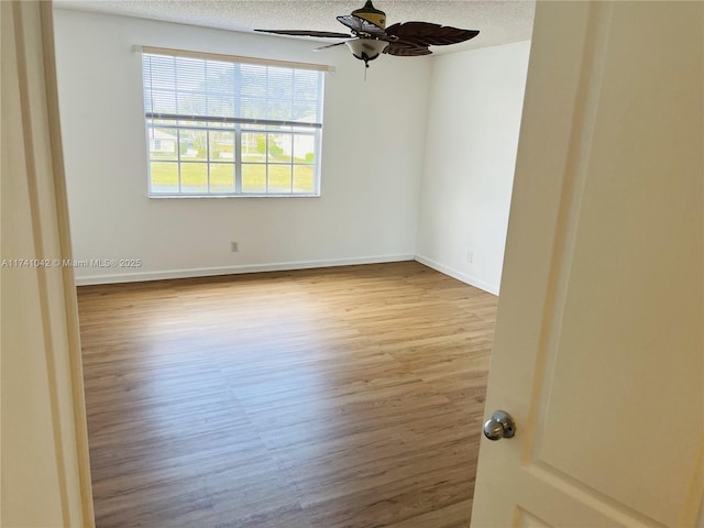 empty room with ceiling fan, a textured ceiling, and light hardwood / wood-style flooring