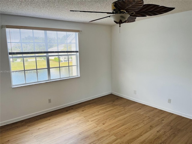 spare room with ceiling fan, a textured ceiling, and light hardwood / wood-style flooring