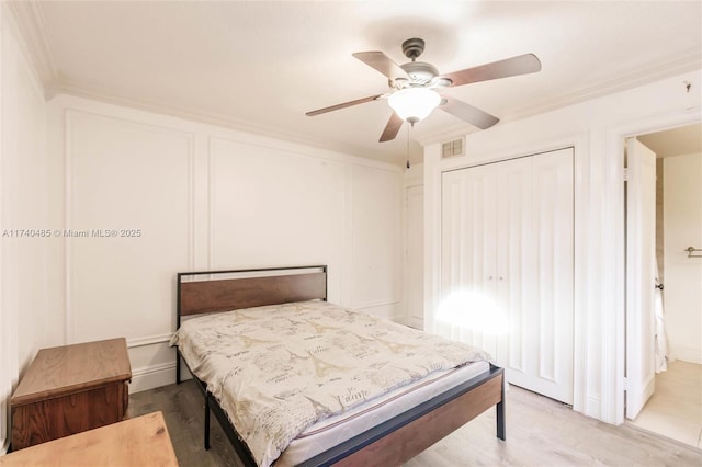 bedroom with ceiling fan, ornamental molding, and light hardwood / wood-style floors