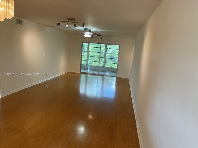 unfurnished room with dark wood-type flooring, ceiling fan, and rail lighting