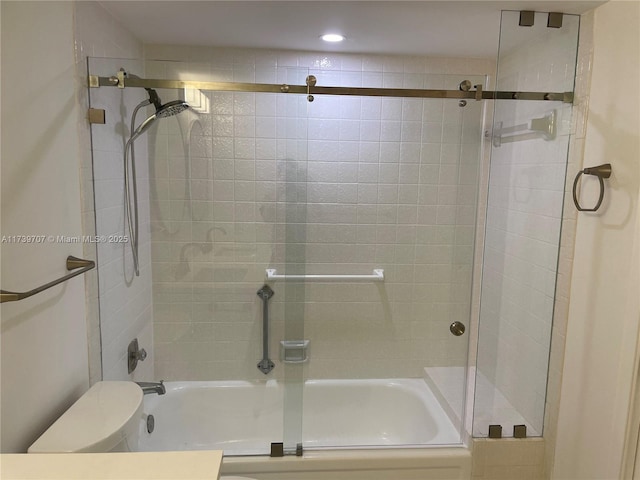 bathroom with toilet and combined bath / shower with glass door