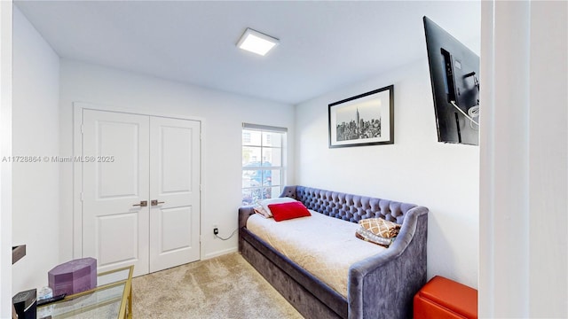 bedroom with light colored carpet and a closet