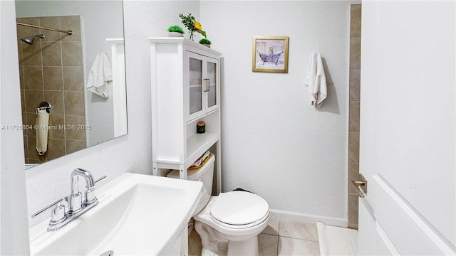 bathroom featuring sink, a tile shower, tile patterned floors, and toilet