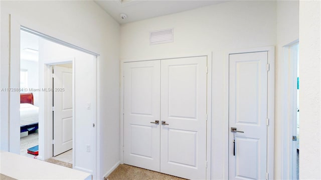 hall with light colored carpet