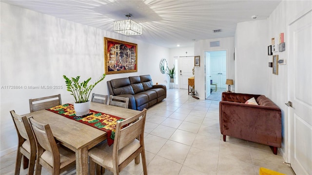dining space with light tile patterned floors and a chandelier