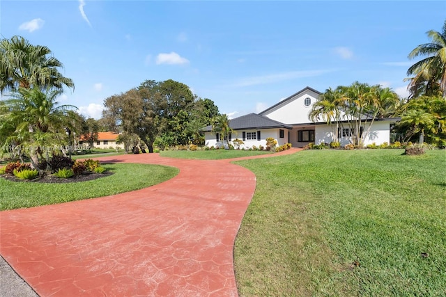 11965 SW 15th Ct, Davie, FL 33325 - view of front facade with a front yard, curved driveway, and stucco siding