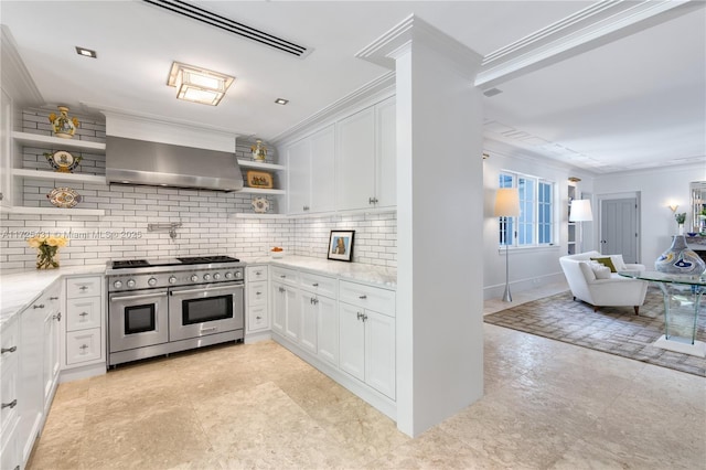 kitchen with crown molding, white cabinetry, extractor fan, and range with two ovens