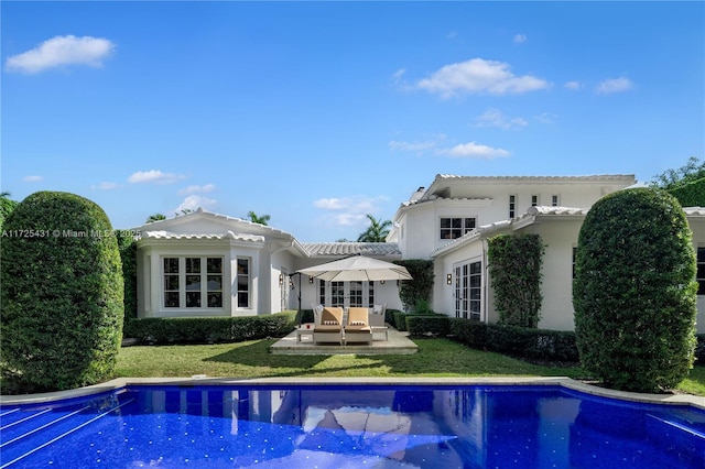 rear view of house featuring a yard, a patio, french doors, and an outdoor hangout area