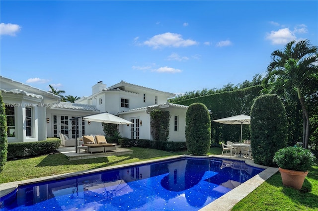 view of pool with french doors, a lawn, and a patio area