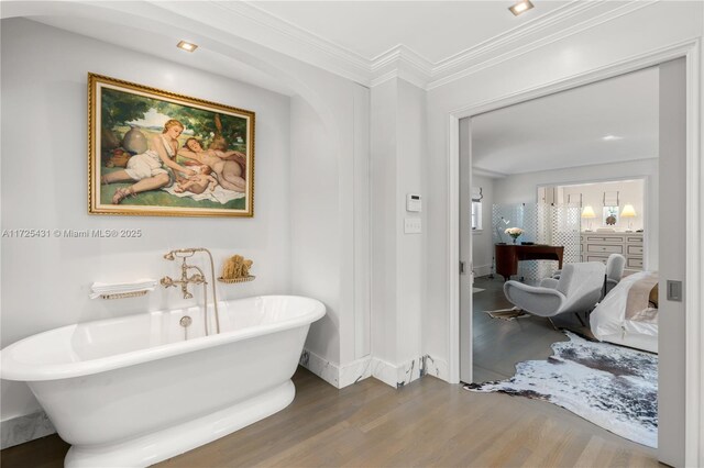 bathroom featuring a bath, wood-type flooring, and ornamental molding