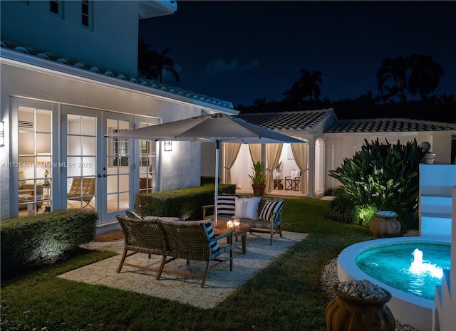 patio at twilight with a yard, french doors, and an outdoor hangout area