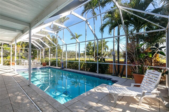 view of swimming pool with a patio and glass enclosure