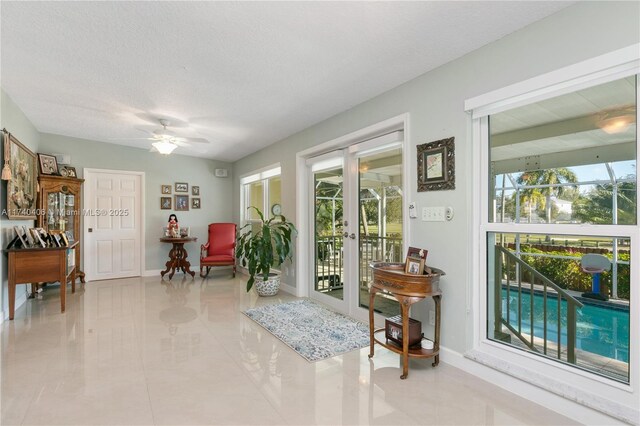 sitting room featuring ceiling fan, a textured ceiling, and french doors