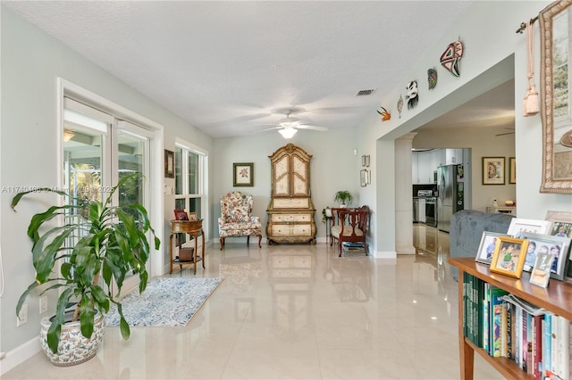 sitting room with ceiling fan and a textured ceiling