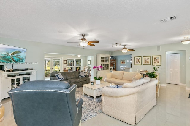 living room featuring ceiling fan and a textured ceiling