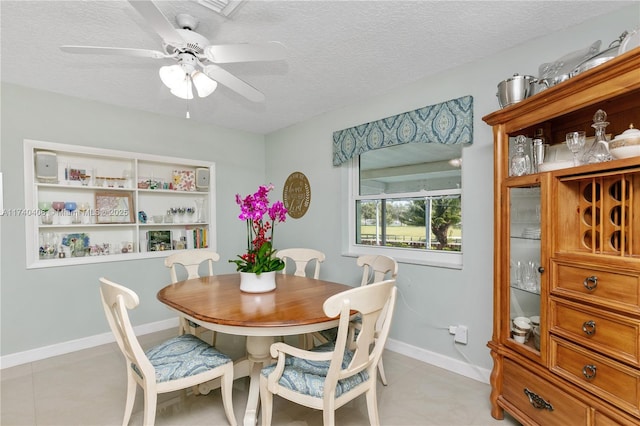 tiled dining room featuring ceiling fan and a textured ceiling