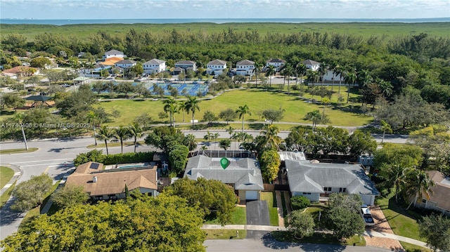 drone / aerial view featuring a wooded view and a residential view