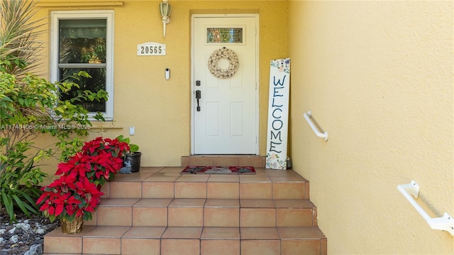 entrance to property featuring stucco siding