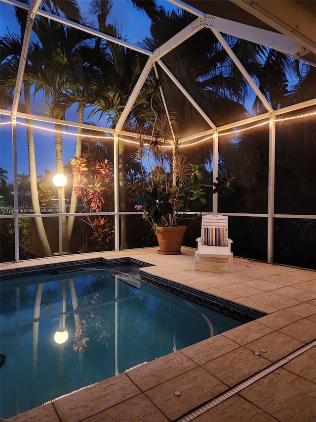 outdoor pool with glass enclosure and a patio