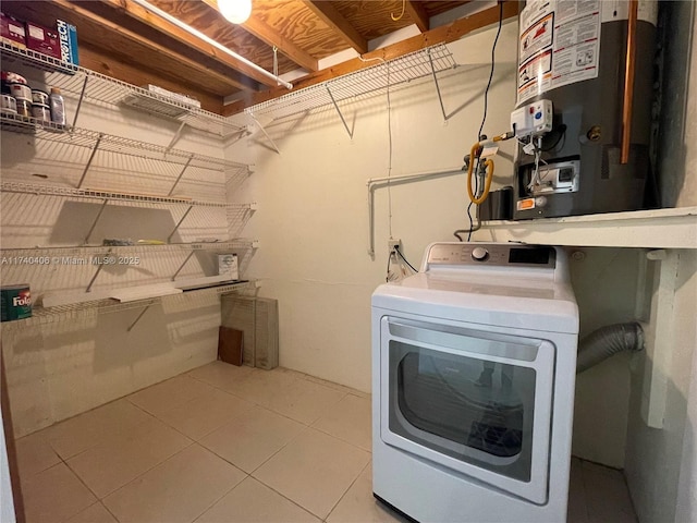 laundry area featuring water heater, laundry area, washer / clothes dryer, and tile patterned floors