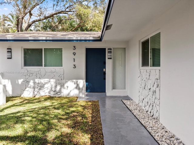 doorway to property with a lawn