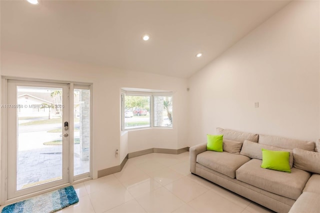 living room with light tile patterned flooring and vaulted ceiling