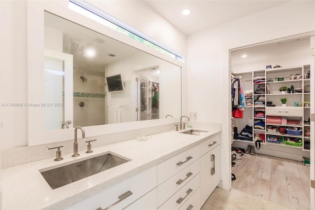 bathroom featuring vanity, wood-type flooring, and a shower with shower door