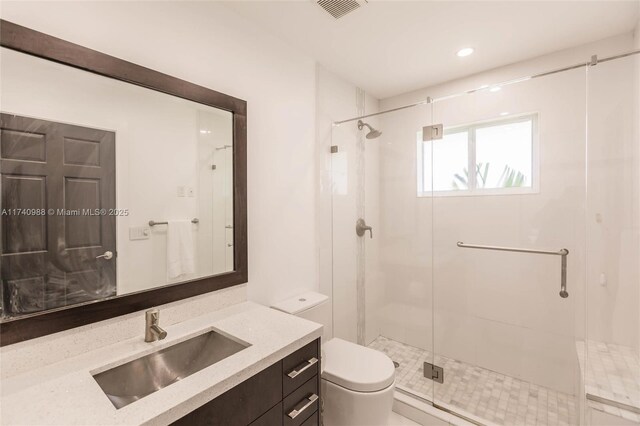 bathroom with vanity, an enclosed shower, and toilet