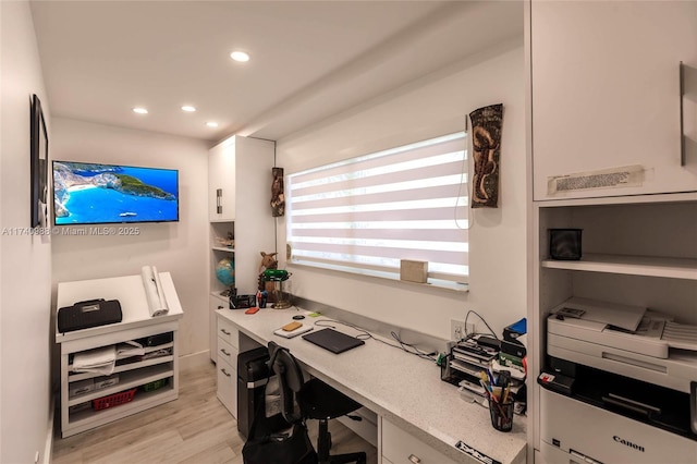 home office with light hardwood / wood-style flooring