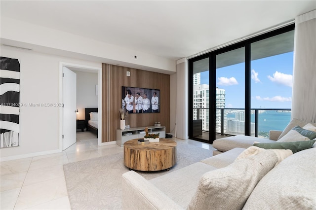 tiled living room featuring expansive windows and a water view