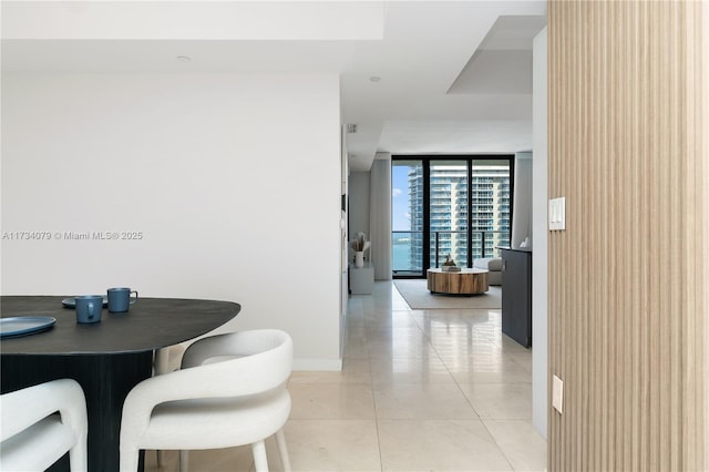 dining area with floor to ceiling windows and light tile patterned floors