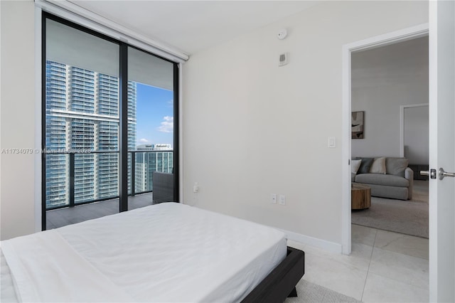 bedroom with floor to ceiling windows, light tile patterned floors, and access to outside