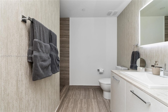 bathroom featuring vanity, hardwood / wood-style floors, and toilet