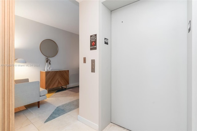 hall with elevator and light tile patterned floors