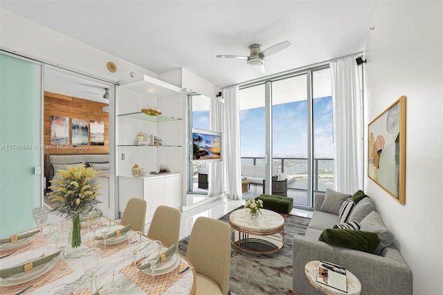 living room featuring a wall of windows and ceiling fan