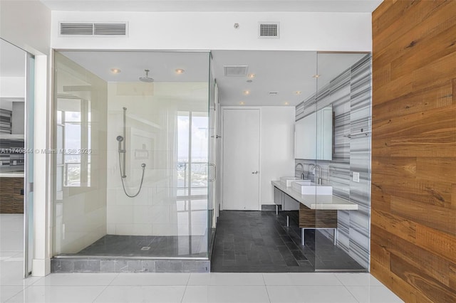 bathroom featuring vanity, tile patterned floors, and tiled shower