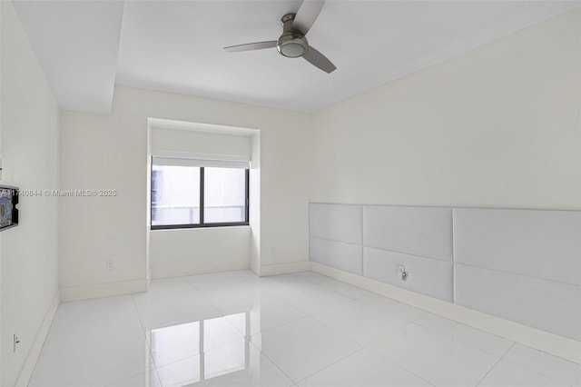 tiled empty room featuring ceiling fan