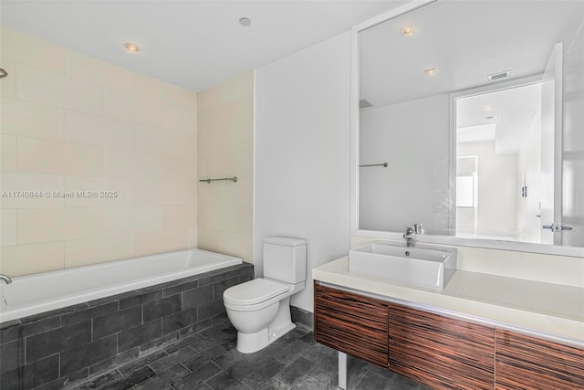 bathroom featuring a relaxing tiled tub, vanity, and toilet