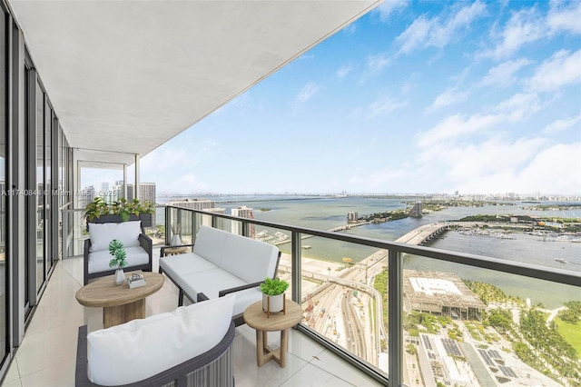 balcony featuring an outdoor living space and a water view