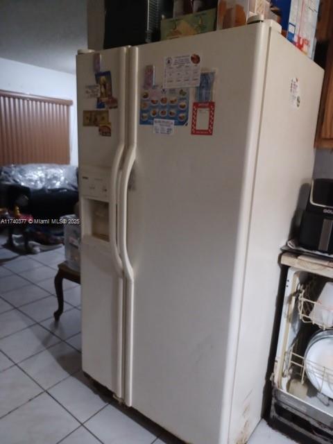 kitchen featuring light tile patterned flooring and white fridge with ice dispenser