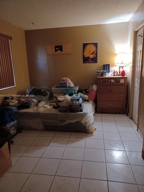 bedroom with light tile patterned floors and a textured ceiling