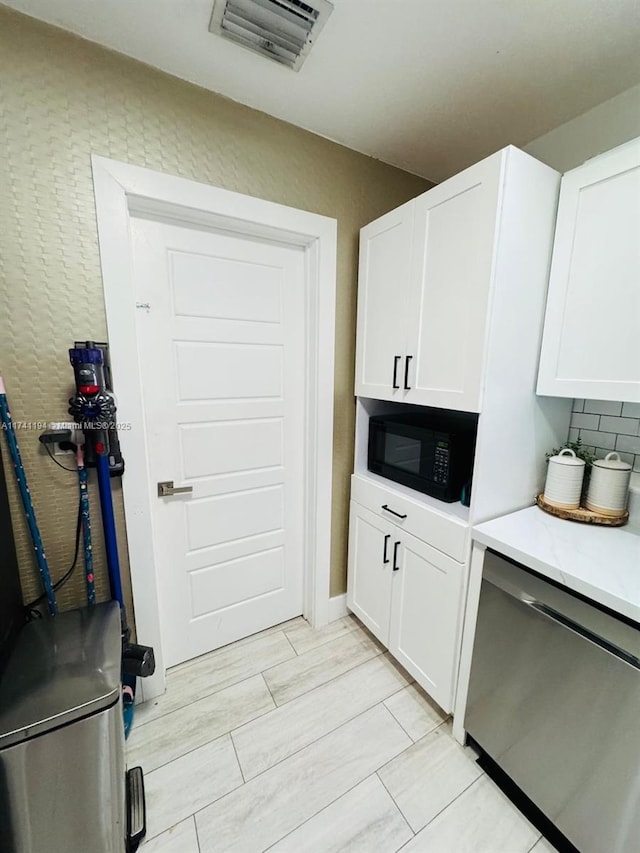 kitchen with white cabinetry, stainless steel dishwasher, and tasteful backsplash