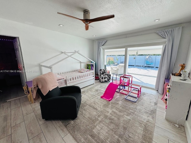 bedroom featuring ceiling fan, access to outside, and a textured ceiling