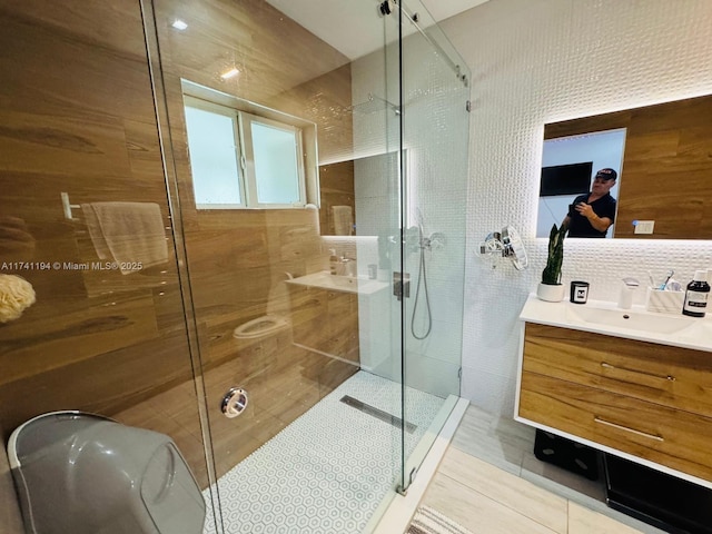 bathroom featuring tile patterned flooring, vanity, tasteful backsplash, and an enclosed shower