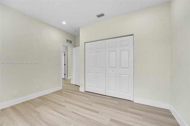 unfurnished bedroom featuring a closet and light hardwood / wood-style flooring