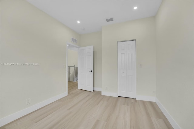 unfurnished bedroom featuring light hardwood / wood-style floors and a closet