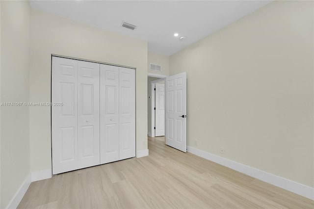 unfurnished bedroom featuring light hardwood / wood-style floors and a closet